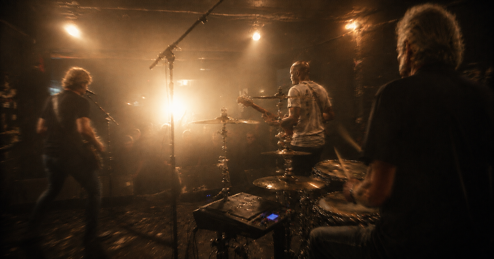 Picnic Tool performing for a crowded room, seen from behind the band